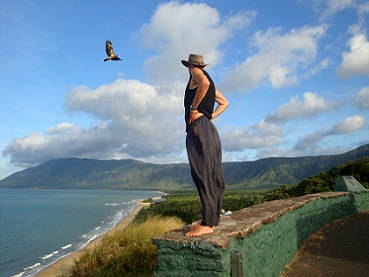 man standing on cliff watching eagle in sky